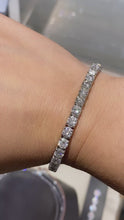 Load and play video in Gallery viewer, Handmade 14k white gold diamond tennis bracelet features 37 round brilliant cut diamonds weighing 12.12 carats total of G color, VS2 clarity, and of excellent cut and brilliance.  Bracelet measures 7" in length.
