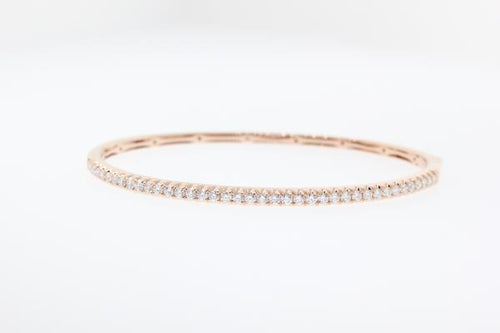14k rose gold diamond bangle bracelet with round brilliant cut diamonds weighing .99 carats total of F color, VS2 clarity.