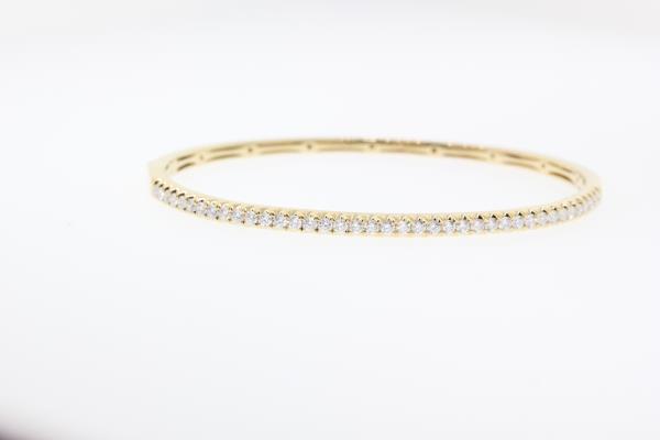 14k yellow gold diamond bangle bracelet with round brilliant cut diamonds weighing .99 carats total of F color, VS2 clarity.